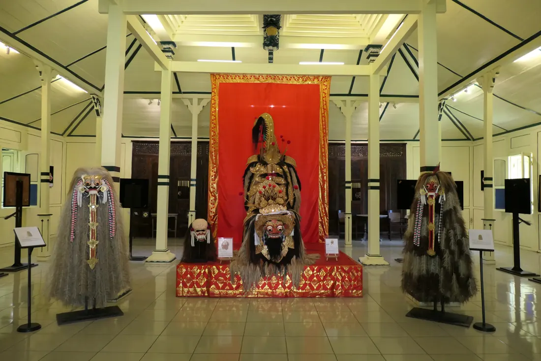 Μια πολύχρωμη μπαλινέζικη φορεσιά Barong με περίτεχνη σκαλιστή και επιχρυσωμένη μάσκα