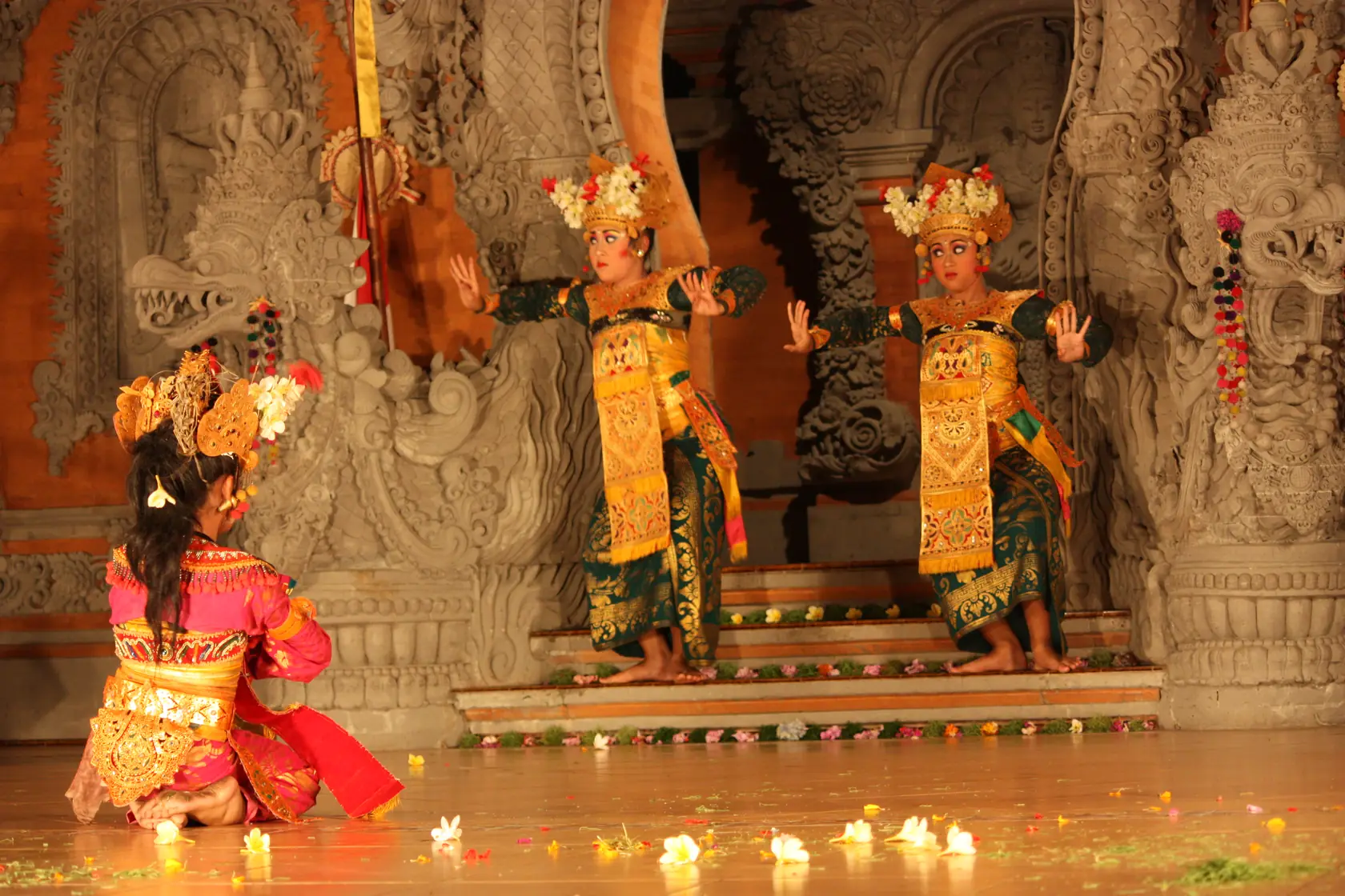 Μια χορεύτρια Balinese Legong με περίτεχνη χρυσή φορεσιά και κόσμημα κεφαλής στη μέση της παράστασης